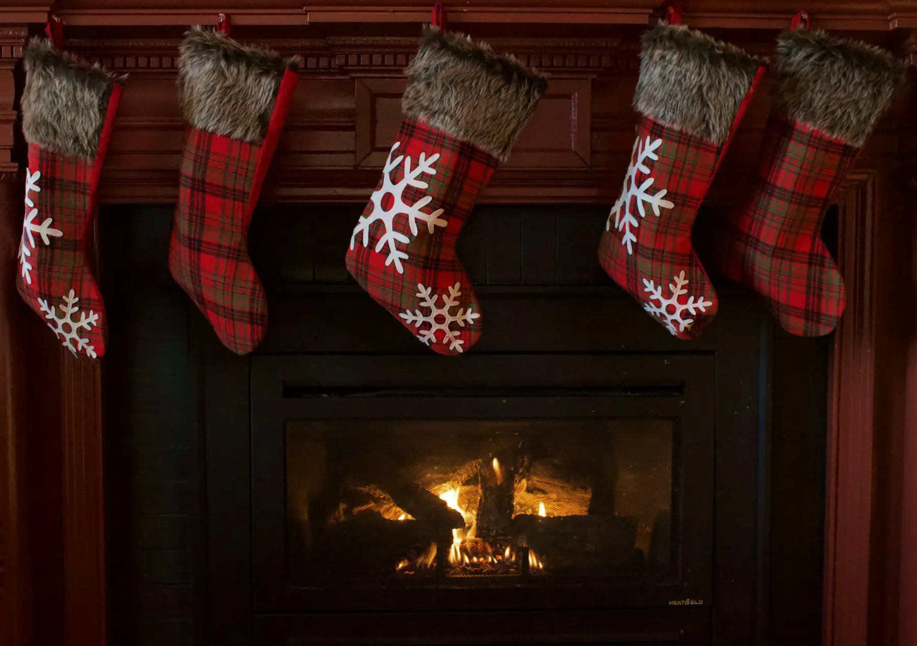 Bas de Noël en tricot rouge et blanc suspendus au-dessus d'un foyer allumé